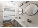 This bathroom includes a double sink vanity, framed mirrors, tile floors, and a shower-tub combo at 332 N Cobblestone St, Gilbert, AZ 85234