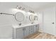 This spacious bathroom includes a double sink vanity with modern lighting, framed mirrors, and wood-look floors at 332 N Cobblestone St, Gilbert, AZ 85234
