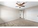 Neutral bedroom featuring carpet, a ceiling fan, and a closet with bi-fold doors at 332 N Cobblestone St, Gilbert, AZ 85234