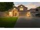 Charming two-story home featuring a well-manicured lawn, mature trees, and a spacious driveway leading to an attached garage at 332 N Cobblestone St, Gilbert, AZ 85234