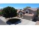 Attractive beige house with a red tile roof, a well-manicured lawn, and a two-car garage at 332 N Cobblestone St, Gilbert, AZ 85234