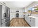 Bright kitchen with stainless steel appliances, white cabinetry, and wood-look floors at 332 N Cobblestone St, Gilbert, AZ 85234