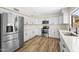 Updated kitchen with white cabinets, stainless steel appliances, and warm wood-look flooring at 332 N Cobblestone St, Gilbert, AZ 85234