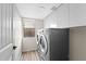 Efficient laundry room with washer, dryer, and ample storage cabinets at 332 N Cobblestone St, Gilbert, AZ 85234