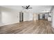 Open-concept living area featuring wood-look tile flooring, a ceiling fan, and seamless flow to the kitchen at 332 N Cobblestone St, Gilbert, AZ 85234