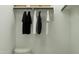 Functional closet featuring hanging clothes, overhead storage, and a plush ottoman at 36570 W Maddaloni Ave, Maricopa, AZ 85138