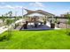 Community picnic area with a playground, BBQ grills, tables, and a grassy common area at 36570 W Maddaloni Ave, Maricopa, AZ 85138
