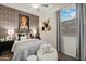 Stylish bedroom with a decorative accent wall, ceiling fan, and a window offering natural light at 46395 W Lander Ln, Maricopa, AZ 85139