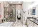Well-lit bathroom with a glass-enclosed shower, a soaking tub, and a view into a walk-in closet at 4777 S Fulton Ranch Blvd # 1032, Chandler, AZ 85248
