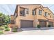 Two-story home with garages, a small balcony, and neutral stucco exterior. It has a brown roof and well-kept landscaping at 4777 S Fulton Ranch Blvd # 1032, Chandler, AZ 85248