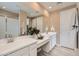 Bright bathroom featuring double sink vanity, a large mirror, and a glass door shower at 4975 S 233Rd Dr, Buckeye, AZ 85326