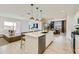 Open-concept kitchen featuring a large island with bar seating, stainless steel appliances, and modern lighting fixtures at 4975 S 233Rd Dr, Buckeye, AZ 85326