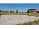 Full basketball court surrounded by trees in the backyard of a house on a sunny day at 5210 W Top Hand Trl, Laveen, AZ 85339
