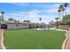 Spacious backyard featuring artificial turf, pool, covered patio, and lounging furniture at 530 E Draper St, Mesa, AZ 85203