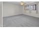 Large, carpeted bedroom with neutral walls, ceiling fan, and large windows at 530 E Draper St, Mesa, AZ 85203
