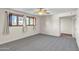 Spacious carpeted bedroom with large windows and a ceiling fan at 530 E Draper St, Mesa, AZ 85203