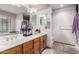 Bathroom featuring double sinks, wood cabinets, large mirrors, and tiled flooring at 5407 W North Ln, Glendale, AZ 85302