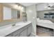 Bathroom with gray cabinets, wooden mirror, and view into bedroom at 633 W Southern Ave # 1131, Tempe, AZ 85282