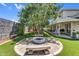 Lush backyard with a fire pit, artificial grass, and an extended covered patio, ideal for relaxation and outdoor enjoyment at 645 S 54Th St, Mesa, AZ 85206