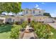 Frontal view of an attractive two-story home with vibrant floral landscaping leading to the welcoming red front door at 645 S 54Th St, Mesa, AZ 85206