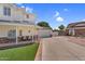 Side view of a spacious home showcasing the covered porch and the entrance to the garage and the long driveway at 645 S 54Th St, Mesa, AZ 85206