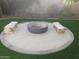 This fire pit has a circle of sand with log benches around the pit, all surrounded by green artificial grass at 645 S 54Th St, Mesa, AZ 85206