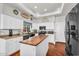 Bright kitchen featuring white cabinets, wooden island countertop, and hardwood flooring at 645 S 54Th St, Mesa, AZ 85206