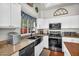 Modern kitchen boasts stainless appliances, granite countertops, a black sink, and white cabinets at 645 S 54Th St, Mesa, AZ 85206
