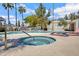 Relaxing community hot tub with inviting blue tile and accessibility rails with a pool and palm trees nearby at 850 S River Dr # 1068, Tempe, AZ 85281