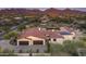 Expansive aerial view of a desert home showcasing the tile roof and three-car garage at 8821 E Havasupai Dr, Scottsdale, AZ 85255