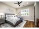 Cozy bedroom with a large window, plantation shutters, hardwood floors, and a ceiling fan at 8821 E Havasupai Dr, Scottsdale, AZ 85255