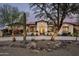 Inviting desert home featuring mature landscaping and a paver driveway at 8821 E Havasupai Dr, Scottsdale, AZ 85255