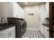 Well-lit laundry room featuring ample white cabinets, a utility sink, and a modern washer and dryer at 8821 E Havasupai Dr, Scottsdale, AZ 85255