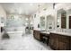 Bright main bathroom with dual sink vanity, freestanding tub, and elegant chandelier lighting at 8821 E Havasupai Dr, Scottsdale, AZ 85255