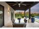 Covered outdoor dining area with a ceiling fan overlooking the backyard and a refreshing pool at 8821 E Havasupai Dr, Scottsdale, AZ 85255