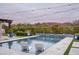 Inviting pool with mountain views, featuring lounge chairs, blue planters, and string lights at 8821 E Havasupai Dr, Scottsdale, AZ 85255