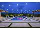 Night shot of a backyard pool area with string lights and desert views at 8821 E Havasupai Dr, Scottsdale, AZ 85255