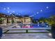 Beautiful backyard pool and patio area with decorative lighting and mountain views at dusk at 8821 E Havasupai Dr, Scottsdale, AZ 85255