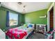 Bright bedroom with a playful green accent wall and a large window providing natural light at 12501 E Cloud Rd, Chandler, AZ 85249