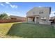 Expansive backyard features a lush lawn, covered patio, and outdoor kitchen, ideal for entertaining guests at 13553 N 141St Ln, Surprise, AZ 85379