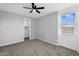 This bedroom has gray paint, carpet, a ceiling fan and a window at 13553 N 141St Ln, Surprise, AZ 85379