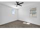 This bedroom has neutral paint, carpet, a ceiling fan and windows for natural light at 13553 N 141St Ln, Surprise, AZ 85379