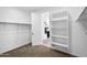 Walk-in closet with built-in shelving and open access to a bathroom at 13553 N 141St Ln, Surprise, AZ 85379