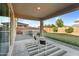 Relaxing covered patio with outdoor dining area, overlooks a large grassy yard with an outdoor kitchen at 13553 N 141St Ln, Surprise, AZ 85379