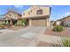 Two-story home with a two-car garage, a neutral-toned exterior, tidy landscaping, and a paved driveway at 13553 N 141St Ln, Surprise, AZ 85379