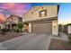 Charming two-story home featuring a well-manicured lawn, a tile roof and a two car garage at 13553 N 141St Ln, Surprise, AZ 85379