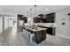 Spacious kitchen with granite countertops, a large island, stainless-steel appliances, and dark wood cabinets at 13553 N 141St Ln, Surprise, AZ 85379