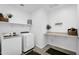 Bright laundry room features modern washer and dryer, plus ample shelving for storage and organization at 13553 N 141St Ln, Surprise, AZ 85379