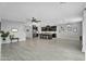 Spacious living area showcasing wood-look tile, dark kitchen cabinets, stainless appliances, and modern light fixtures at 13553 N 141St Ln, Surprise, AZ 85379
