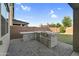 The outdoor kitchen has an easy to clean tile surround, built in grill, sink and plenty of storage at 13553 N 141St Ln, Surprise, AZ 85379